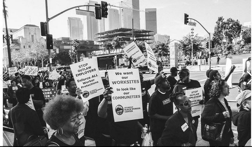 Black and white photo of people marching down an LA street