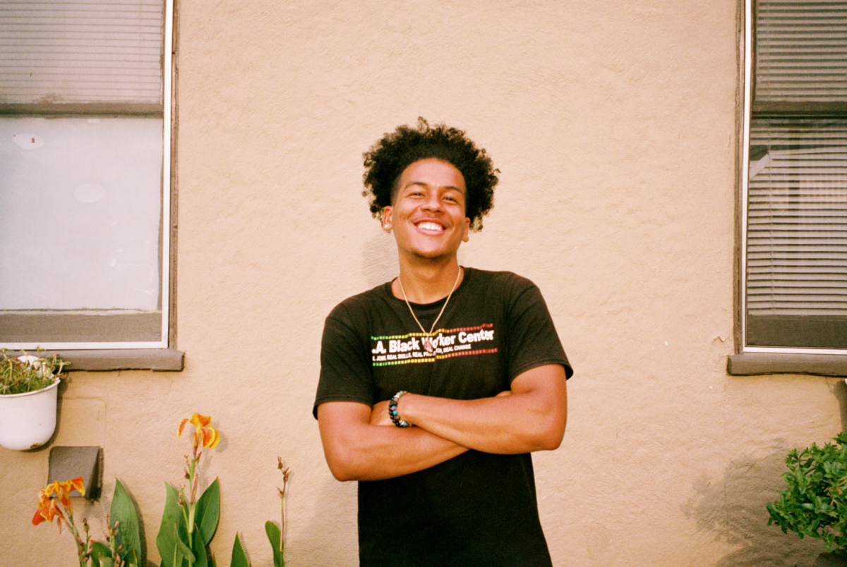 Photo portrait of a young black man in an "LA Black Worker Center" T shirt
